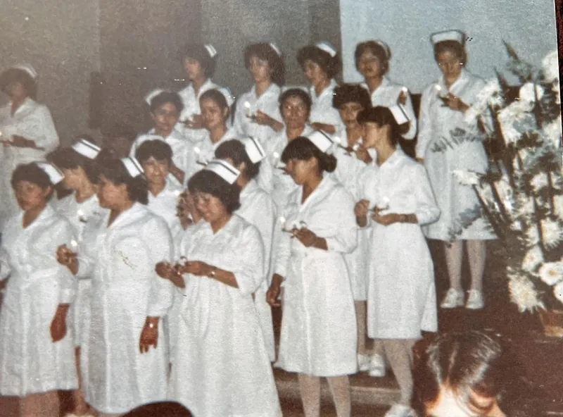 Ceremonia de enfermería: estudiantes con uniforme blanco y cofia sosteniendo velas