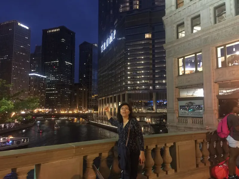 Patricia Moreno de viaje, de noche junto a un río y rascacielos