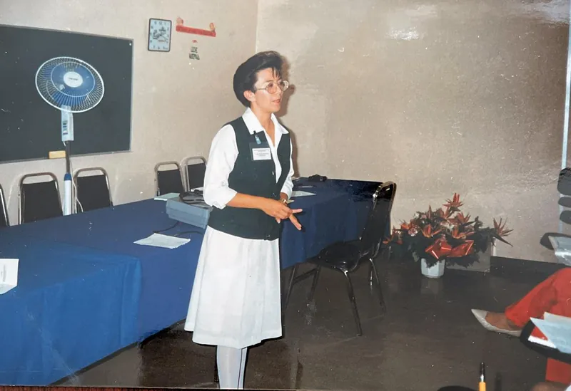 Patricia Moreno con uniforme de enfermería frente a un grupo en un aula de capacitación