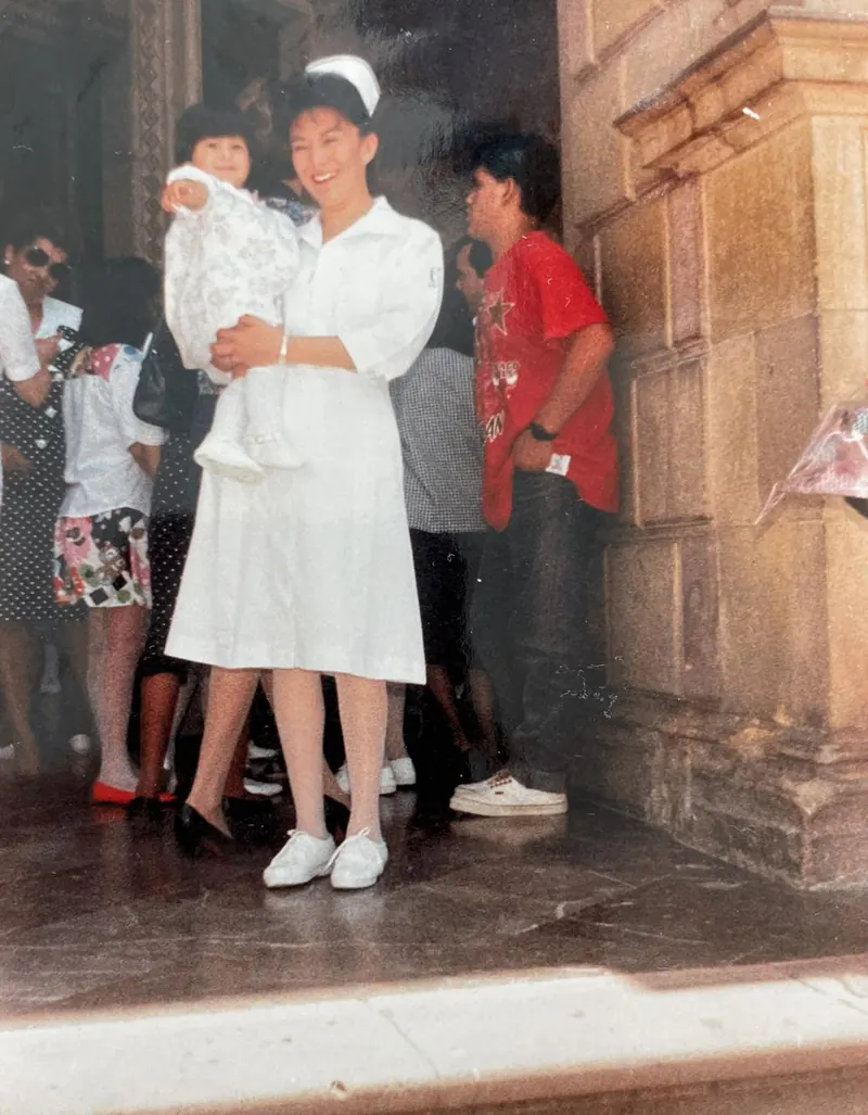 Patricia Moreno con uniforme de enfermera cargando a su hija