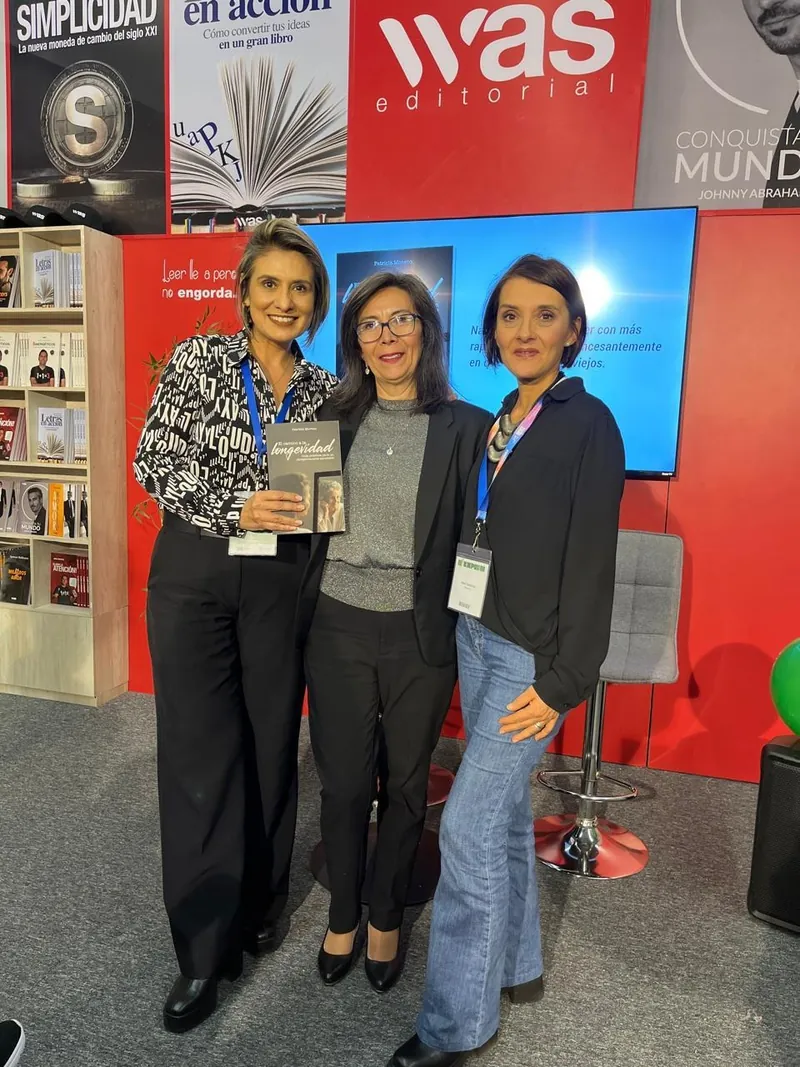 Patricia Moreno con dos amigas en el stand de WAS Editorial, con su libro El camino a la longevidad